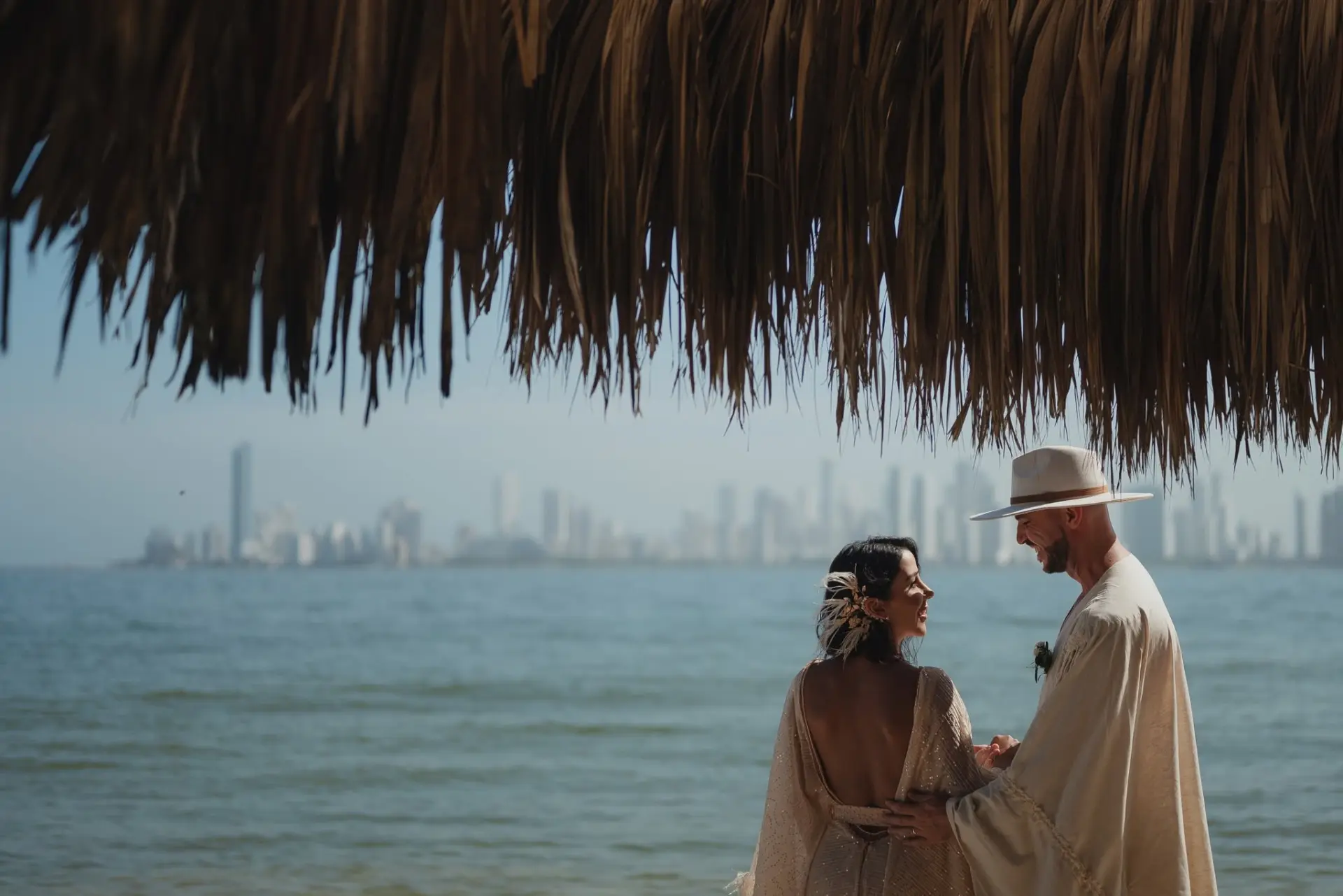 Una coppia di sposi sulla spiaggia di Vista Mare, con la skyline di Cartagena